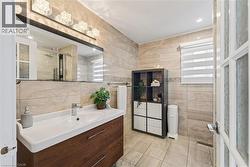 Contemporary vanity with a rectangular basin sink, chrome faucet, and wood-finish cabinetry - 