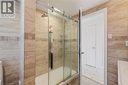 Glass-enclosed shower with horizontal tile surround and a rain showerhead - 