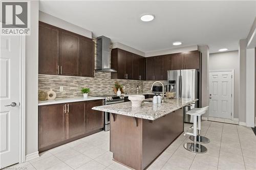 Modern kitchen featuring dark wood-finish cabinetry, light-colored countertops, and a full tile backsplash - 96 Damselfly Way, Ottawa, ON - Indoor Photo Showing Kitchen With Upgraded Kitchen