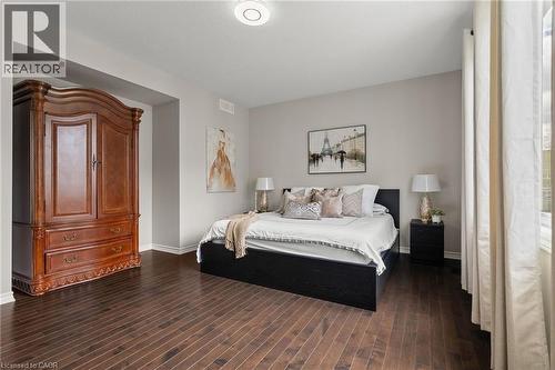 Spacious room featuring rich wood-finish flooring, light grey wall tones, and white baseboards - 96 Damselfly Way, Ottawa, ON - Indoor Photo Showing Bedroom