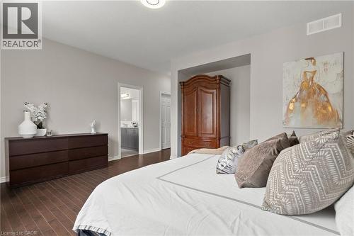 Spacious bedroom featuring wood-finish flooring, light grey wall paint, and a recessed alcove - 96 Damselfly Way, Ottawa, ON - Indoor Photo Showing Bedroom
