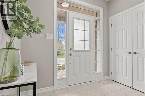 Entryway featuring a white paneled door with decorative glass, two sidelight windows, a transom window, and light-toned tile flooring - 96 Damselfly Way, Ottawa, ON - Indoor Photo Showing Other Room