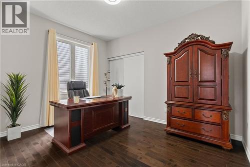 Spacious room featuring dark wood-finish flooring, light grey walls, and a large window with blinds - 96 Damselfly Way, Ottawa, ON - Indoor Photo Showing Office