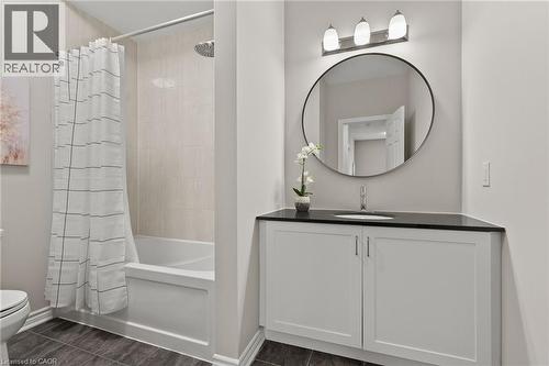 Bathroom featuring a white vanity with slab cabinet doors, a black countertop, and an undermount sink - 96 Damselfly Way, Ottawa, ON - Indoor Photo Showing Bathroom