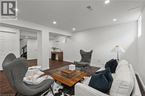 Spacious room featuring wood-finish flooring, recessed lighting, white walls, and a window providing ambient light - 96 Damselfly Way, Ottawa, ON - Indoor