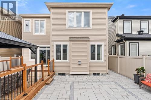 Rear exterior featuring light beige siding and multiple windows - 96 Damselfly Way, Ottawa, ON - Outdoor With Exterior