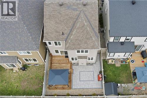 Rear exterior featuring a multi-level wood deck, a patio with paver stones, a gravel area with a dark blue gazebo, and a white privacy fence - 96 Damselfly Way, Ottawa, ON - Outdoor