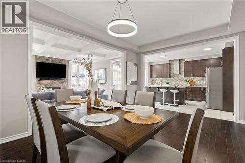 Dining area featuring dark wood-finish flooring, a contemporary circular pendant light, and framed openings - 96 Damselfly Way, Ottawa, ON - Indoor Photo Showing Dining Room