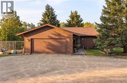 Brown siding exterior with a prominent attached garage and a multi-pane front entry door - 