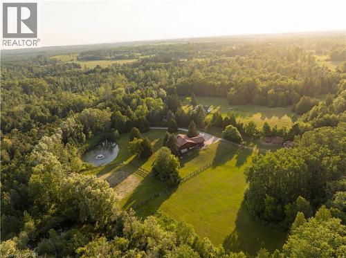 Expansive estate featuring a brown-toned residence, a private pond with a fountain, and extensive green space - 12613 Second Line, Milton, ON - Outdoor With View