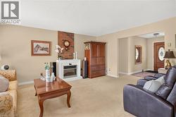 Living area featuring a brick accent wall with a white mantel and an electric fireplace insert - 