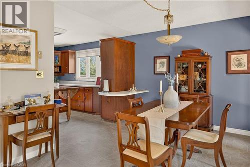 Kitchen and dining area featuring wood cabinetry, white countertops, a drop-leaf table, and tile flooring - 12613 Second Line, Milton, ON - Indoor Photo Showing Dining Room