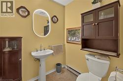 Pedestal sink featuring a dual-handle faucet and an illuminated oval mirror - 
