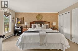 Bedroom featuring carpet flooring, a decorative wall panel, and two bi-fold closet doors - 
