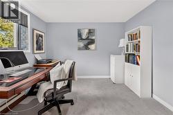 Carpeted room featuring light gray wall paint, white baseboards, and a window with black blinds - 