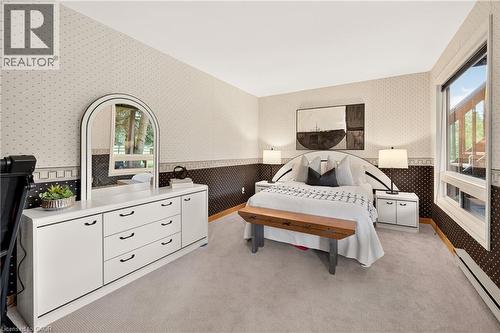 Carpeted bedroom featuring patterned wallpaper, crisp white ceilings, and a large window - 12613 Second Line, Milton, ON - Indoor Photo Showing Bedroom
