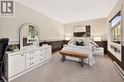 Carpeted bedroom featuring patterned wallpaper, crisp white ceilings, and a large window - 