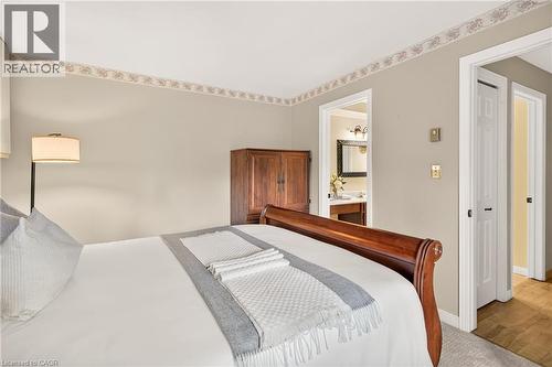 Bedroom featuring light beige wall paint, a decorative ceiling border, and a wood-finish armoire - 12613 Second Line, Milton, ON - Indoor Photo Showing Bedroom