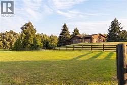 Expansive green lawn outlined by a dark wood fence - 