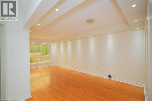 Spacious room featuring wood-finish flooring, recessed ceiling lighting, a large window, and light-toned wall finishes - 18 Heritage Drive, Guelph, ON - Indoor Photo Showing Other Room