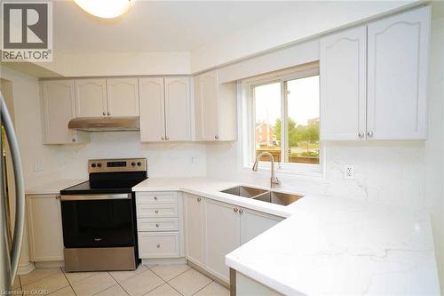 Kitchen featuring white cabinetry, light-toned countertops with veining, stainless steel range with overhead vent, and a double basin sink with a gooseneck faucet - 18 Heritage Drive, Guelph, ON - Indoor Photo Showing Kitchen With Double Sink