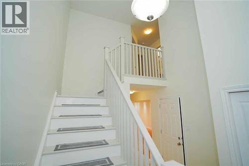 Two-story entryway featuring a white painted staircase with matching banister and balusters - 18 Heritage Drive, Guelph, ON - Indoor Photo Showing Other Room