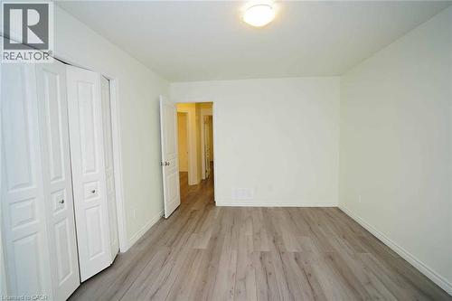 Spacious room featuring light wood-finish flooring, neutral wall tones, and a flush-mount ceiling light - 18 Heritage Drive, Guelph, ON - Indoor Photo Showing Other Room