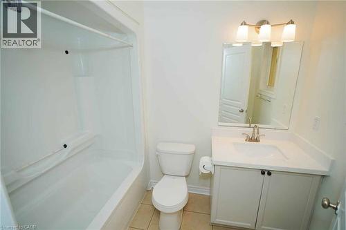 Bathroom featuring a white vanity with an integrated sink, brushed nickel faucet, and a rectangular mirror - 18 Heritage Drive, Guelph, ON - Indoor Photo Showing Bathroom