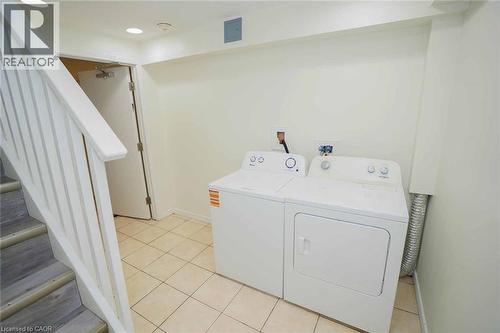 Dedicated laundry area featuring a white top-load washing machine and front-load dryer - 18 Heritage Drive, Guelph, ON - Indoor Photo Showing Laundry Room