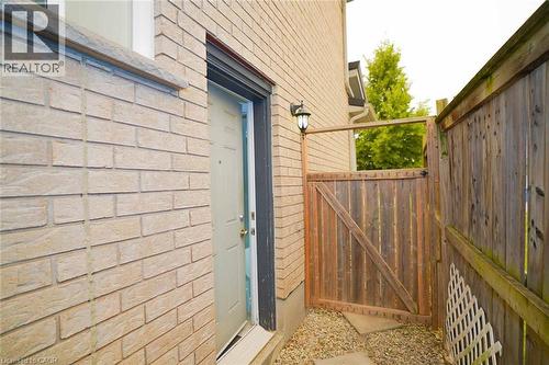 Exterior brick siding featuring a privacy fence and gate - 18 Heritage Drive, Guelph, ON - Outdoor With Exterior
