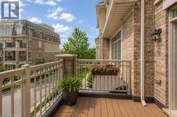Private balcony with composite wood-finish decking and metal railings - 