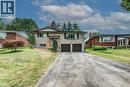 Residence featuring a stone and siding exterior, an elevated front entrance with wood railing, a two-car attached garage with dark wood-look doors, and a paved driveway - 109 White Oak Place, Waterloo, ON  - Outdoor With Facade 