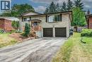 Stone facade residence featuring a covered front entrance with wood railings, a two-car garage, and mature landscaping - 109 White Oak Place, Waterloo, ON  - Outdoor 