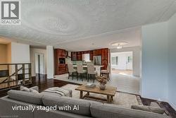 Open-concept living area with dark wood-finish flooring, a textured ceiling, and recessed lighting - 