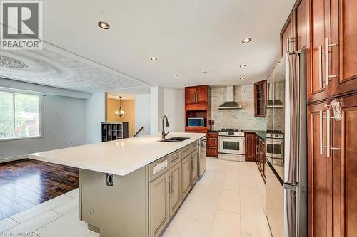 Kitchen featuring a central island with an integrated sink, stainless steel appliances, dark wood cabinetry, and recessed lighting - 109 White Oak Place, Waterloo, ON - Indoor Photo Showing Kitchen With Double Sink With Upgraded Kitchen