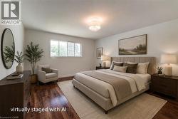 Spacious bedroom featuring rich wood-finish flooring, a contemporary semi-flush mount light fixture, and a wide window offering natural light - 