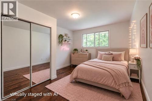Bedroom featuring dark wood-finish flooring, white baseboards, and a large window - 109 White Oak Place, Waterloo, ON - Indoor Photo Showing Bedroom