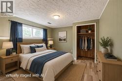 Bedroom featuring a wood-finish flooring, two window openings, and a built-in closet with shelving and hanging rod - 