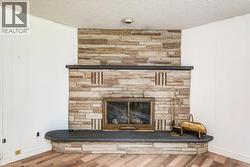Stone-clad fireplace with a dark stone hearth and mantelpiece, set against vertical plank paneling - 