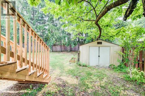 Expansive rear yard featuring a newly constructed wooden staircase, a freestanding storage shed, and mature perimeter fencing - 109 White Oak Place, Waterloo, ON - Outdoor