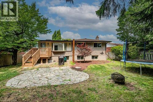 Expansive backyard featuring a stone patio, elevated wood deck with stairs, and mature trees - 109 White Oak Place, Waterloo, ON - Outdoor