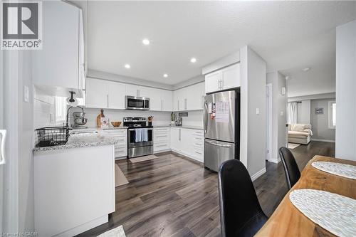 Contemporary kitchen featuring white cabinetry, light-toned countertops, stainless steel appliances, recessed lighting, and wood-finish flooring - 750 Lawrence Street Unit# 38, Cambridge, ON - Indoor