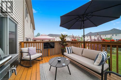 Spacious wood-finish deck with a privacy railing, featuring a mounted outdoor television and direct access to interior via sliding glass doors - 750 Lawrence Street Unit# 38, Cambridge, ON - Outdoor With Deck Patio Veranda With Exterior