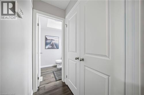 Hallway featuring wood-finish flooring, light grey painted walls, and white paneled doors with chrome hardware - 750 Lawrence Street Unit# 38, Cambridge, ON - Indoor Photo Showing Other Room