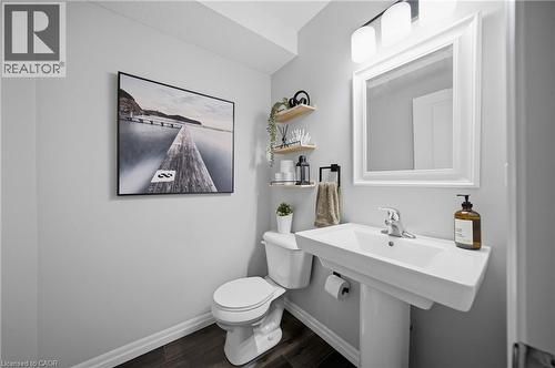 Pedestal sink with a chrome faucet, illuminated by a two-bulb vanity light - 750 Lawrence Street Unit# 38, Cambridge, ON - Indoor Photo Showing Bathroom
