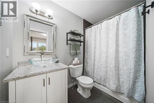 Bathroom featuring a contemporary vessel sink, stone-finish countertop, white cabinetry, and an enclosed shower - 750 Lawrence Street Unit# 38, Cambridge, ON - Indoor Photo Showing Bathroom