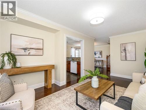 Living area featuring dark wood-finish flooring, light-toned walls, and white crown molding - 656 Frank Place, Milton, ON - Indoor Photo Showing Living Room