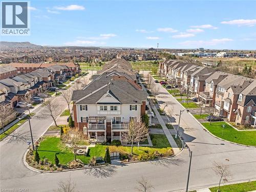 Contemporary multi-level townhome featuring a light-colored facade, dark shingled roof, and multiple balconies - 656 Frank Place, Milton, ON - Outdoor With View