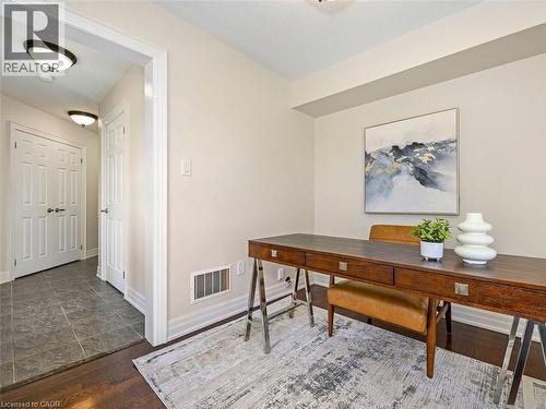 Inviting room featuring dark wood-finish flooring, light neutral wall tones, and recessed lighting - 656 Frank Place, Milton, ON - Indoor Photo Showing Other Room