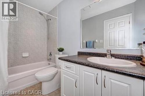 Bathroom featuring a white vanity with cabinet storage, integrated sink, and dark patterned countertop - 175 David Bergey Drive Unit# L74, Kitchener, ON - Indoor Photo Showing Bathroom